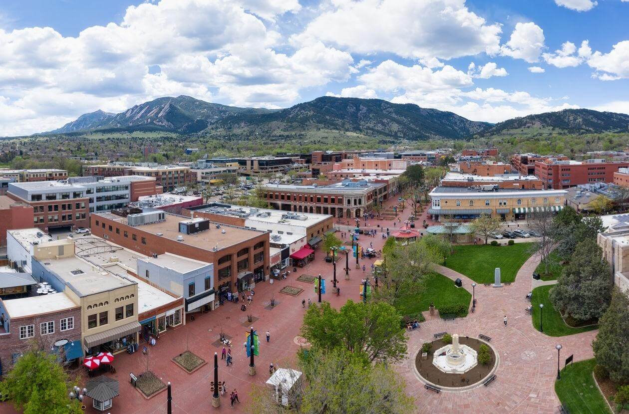 Aerial view of Pearl Street in Boulder, Colorado with the Rocky Mountains in the background - all home to the Dr. Ida Rolf Institute.